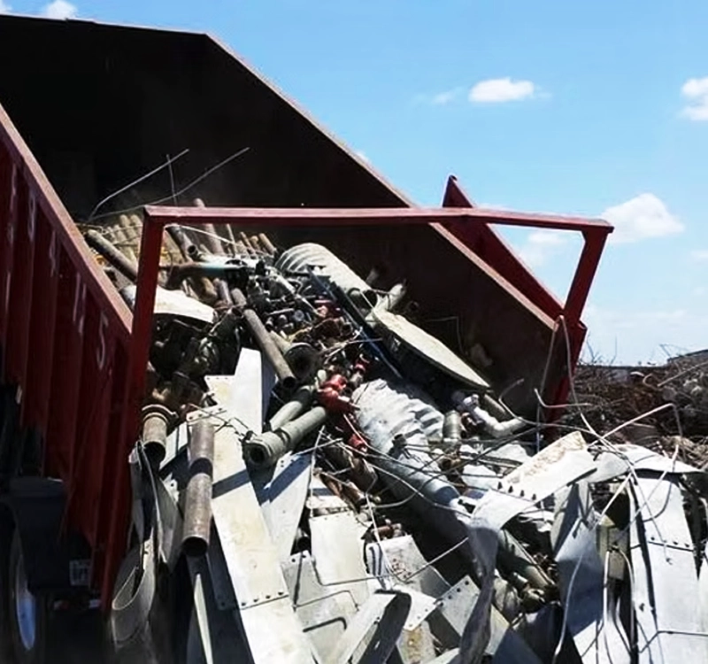 End dump trailer unloading scrap metal at construction site